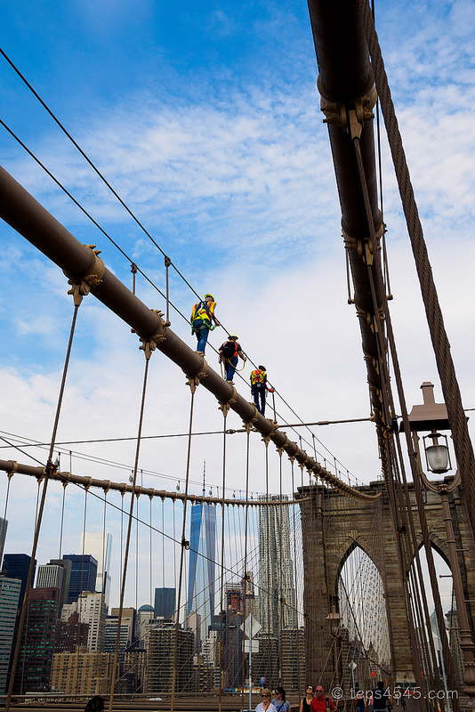 Maintenance workers climbing the Brooklyn Bridge